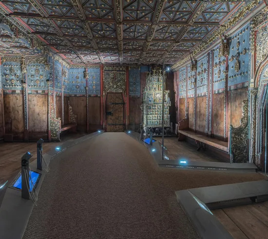 Prunkvoller Holzraum mit bemalter Decke und Wänden, zeigt historische osteuropäische Innenarchitektur